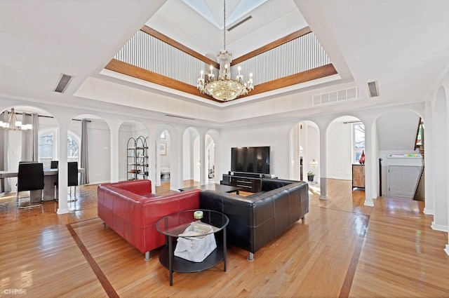 living room featuring crown molding, a notable chandelier, and a tray ceiling