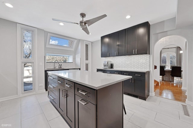 kitchen featuring a healthy amount of sunlight, a center island, and backsplash