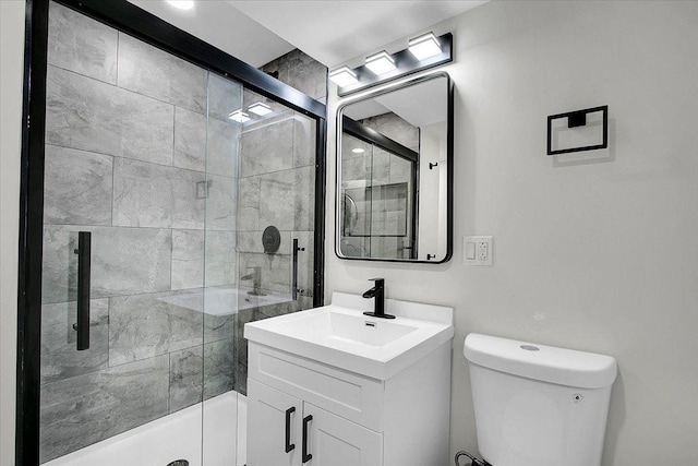 bathroom with vanity, toilet, and a shower with shower door