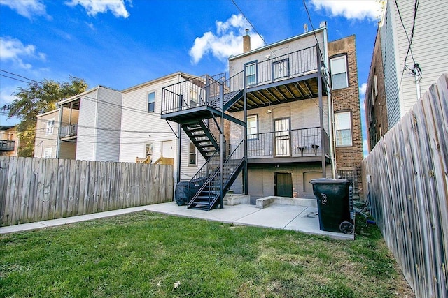 back of property with a lawn and a patio