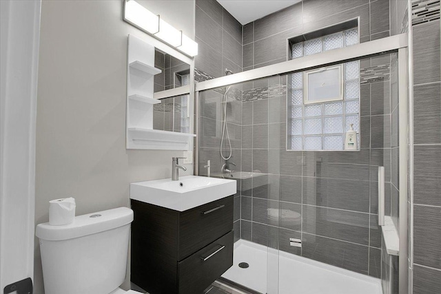 bathroom with an enclosed shower, vanity, and toilet