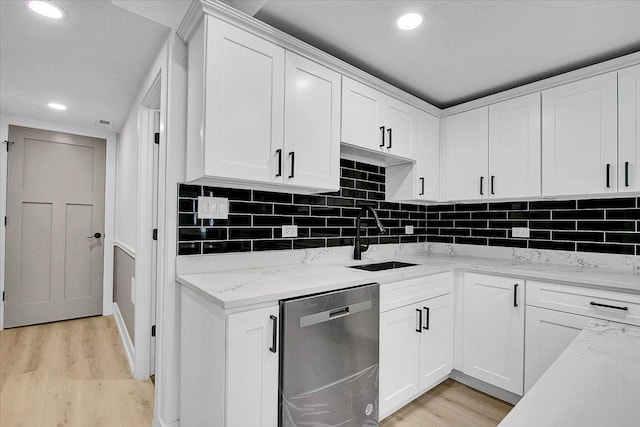 kitchen featuring stainless steel dishwasher, light hardwood / wood-style floors, white cabinets, and sink