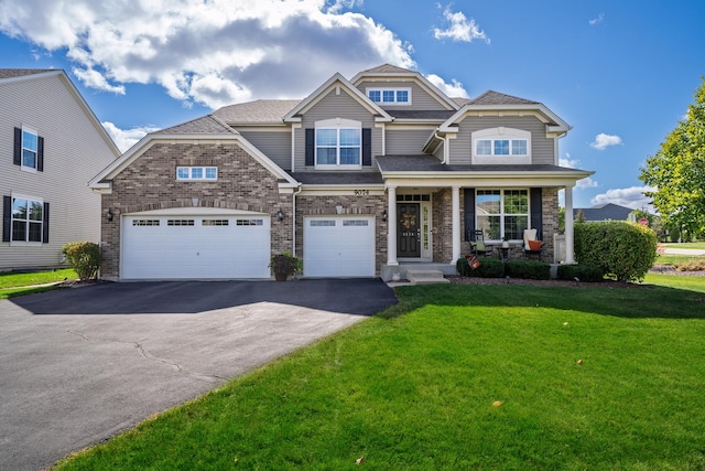 craftsman inspired home with covered porch, a front yard, and a garage