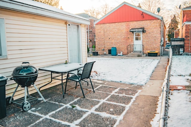 snow covered patio with a grill