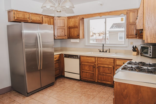 kitchen featuring stainless steel fridge, sink, and white dishwasher