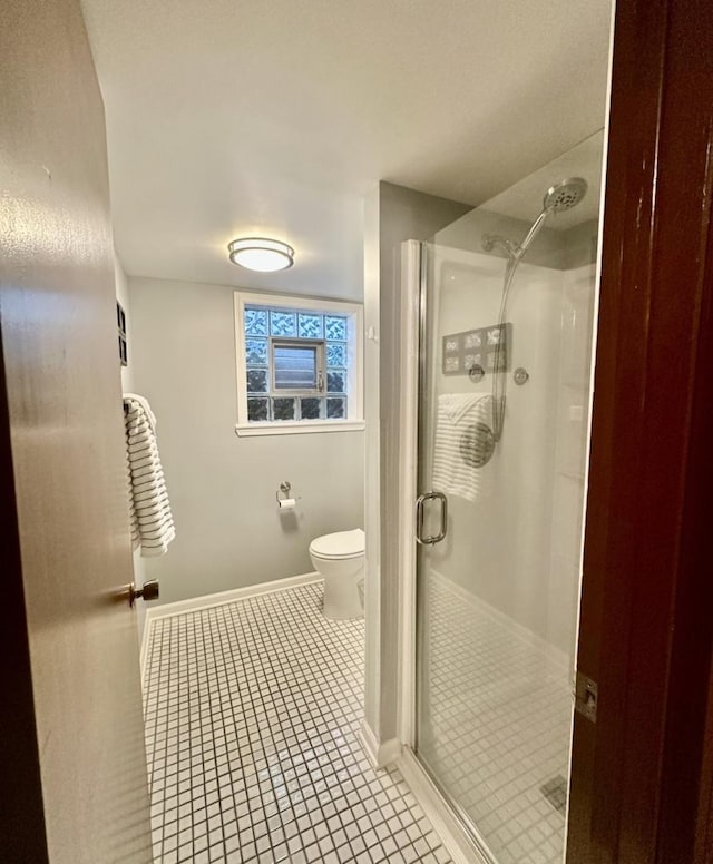 bathroom with tile patterned floors, toilet, and walk in shower