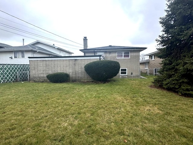 rear view of property featuring a lawn