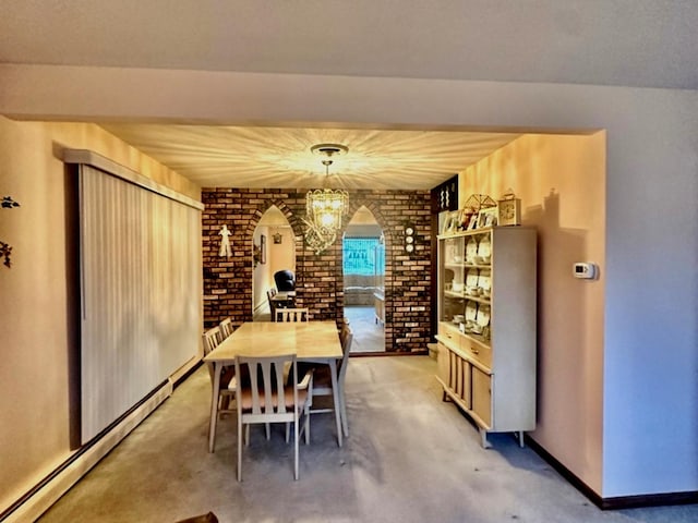 dining area with an inviting chandelier and a baseboard heating unit