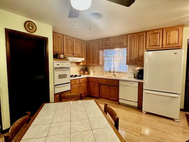 kitchen with ceiling fan, sink, white appliances, and light wood-type flooring