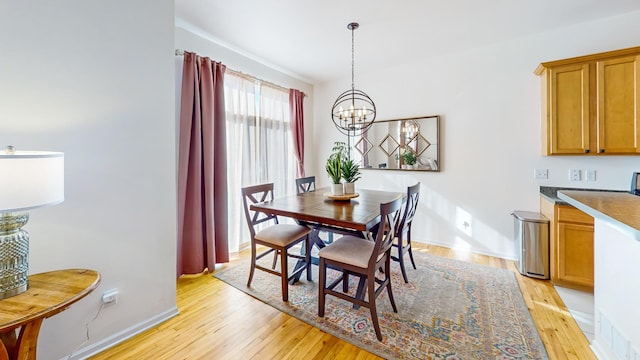 dining space with an inviting chandelier and light wood-type flooring