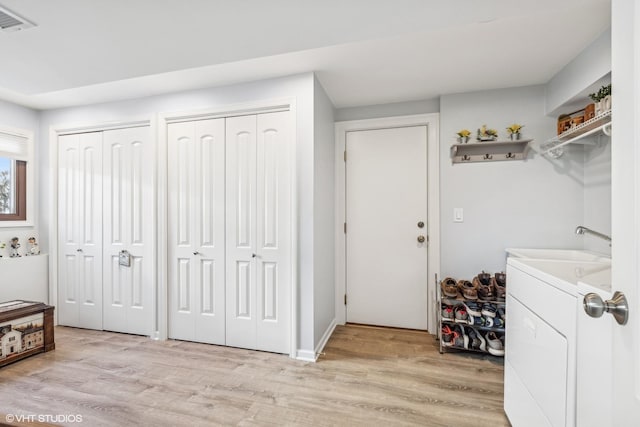 laundry room featuring washer / dryer, light hardwood / wood-style floors, and sink