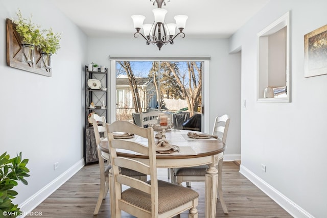 dining area with hardwood / wood-style floors and a chandelier