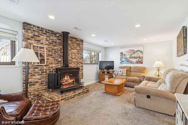 living room with a wood stove and carpet