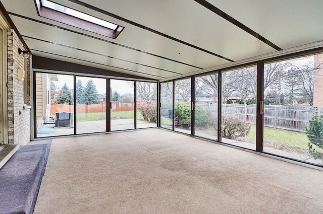 unfurnished sunroom with vaulted ceiling with skylight