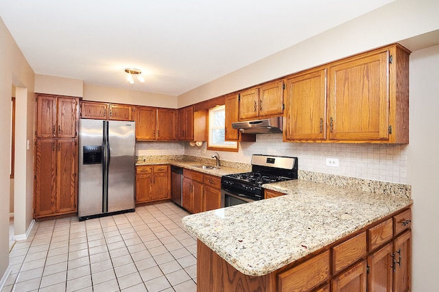 kitchen featuring under cabinet range hood, decorative backsplash, brown cabinets, and stainless steel appliances