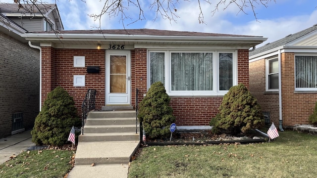 view of exterior entry featuring a lawn