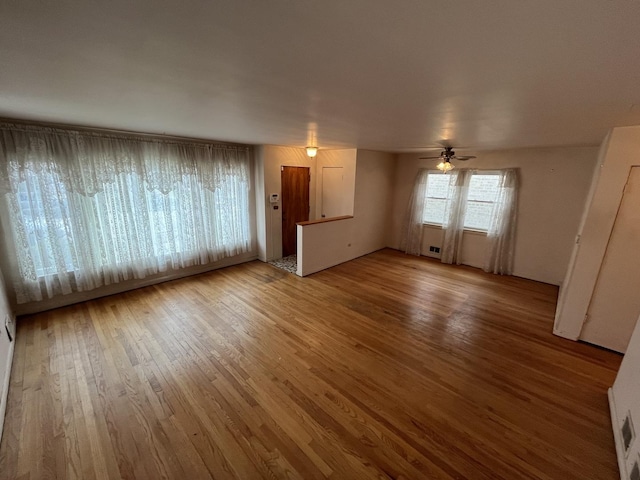 unfurnished living room featuring ceiling fan and wood-type flooring