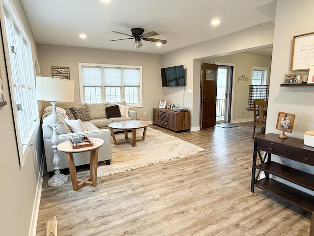 living room with ceiling fan and light hardwood / wood-style floors