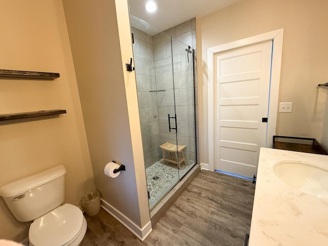 bathroom featuring toilet, hardwood / wood-style floors, vanity, and walk in shower