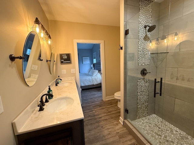 bathroom with hardwood / wood-style flooring, vanity, toilet, and an enclosed shower