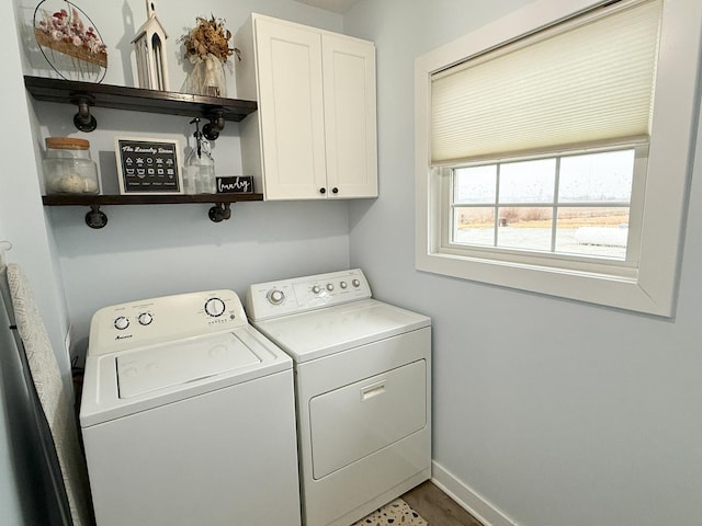 laundry area featuring cabinets, washing machine and dryer, and hardwood / wood-style flooring