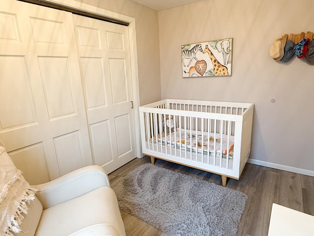 bedroom featuring hardwood / wood-style flooring, a closet, and a crib