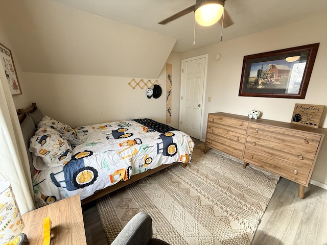 bedroom featuring hardwood / wood-style flooring, ceiling fan, and vaulted ceiling