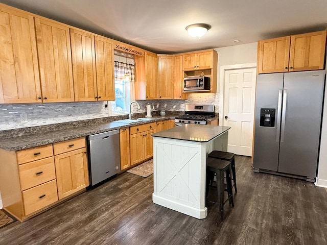 kitchen with pendant lighting, sink, dark wood-type flooring, stainless steel appliances, and a center island