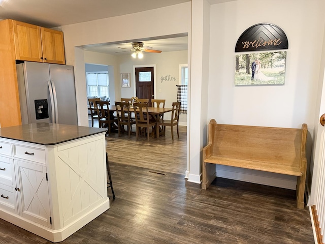 kitchen featuring dark wood-type flooring, ceiling fan, stainless steel fridge with ice dispenser, and white cabinets