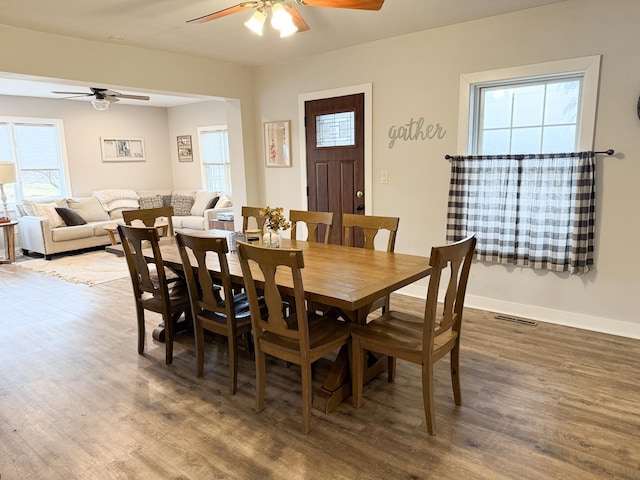 dining space with hardwood / wood-style flooring and ceiling fan