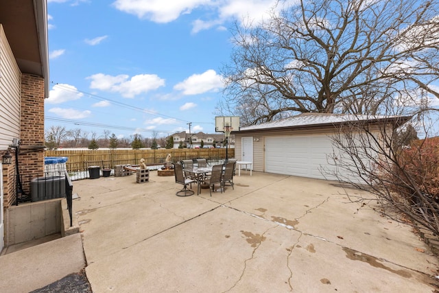 view of patio featuring a garage, an outdoor structure, and an outdoor fire pit