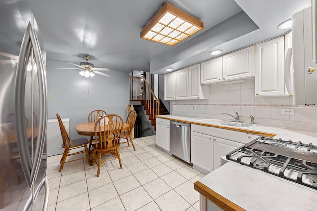 kitchen with white cabinets, stainless steel appliances, ceiling fan, and sink