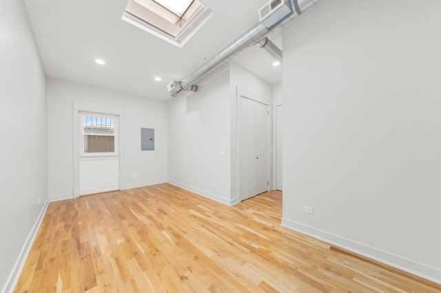 spare room with light hardwood / wood-style floors and electric panel