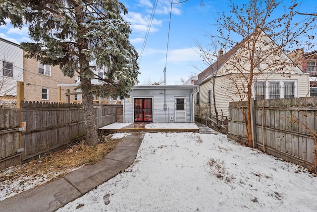 view of snow covered back of property