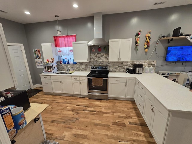 kitchen with stainless steel electric range, white cabinets, and light countertops