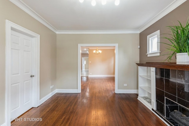 unfurnished living room with dark hardwood / wood-style floors, an inviting chandelier, and ornamental molding