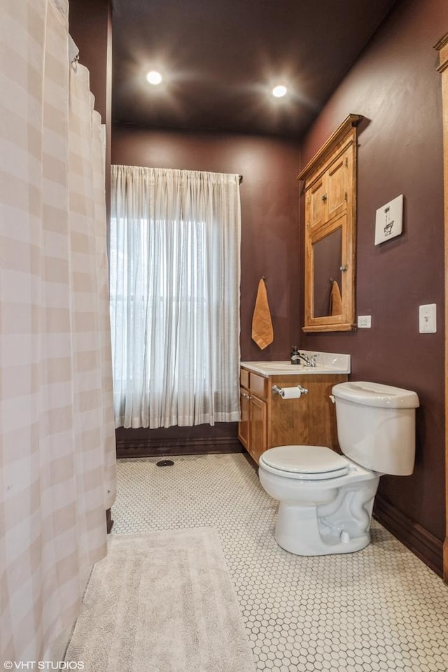 bathroom with toilet, vanity, and tile patterned floors