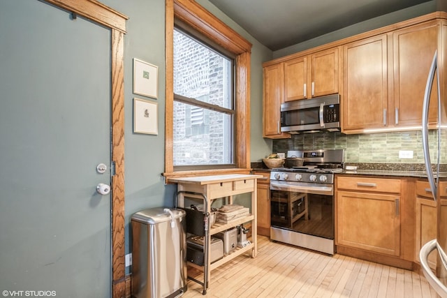 kitchen featuring dark stone counters, appliances with stainless steel finishes, and decorative backsplash