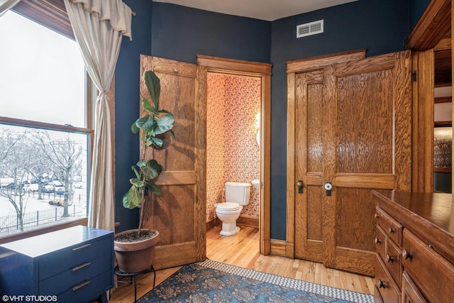 bathroom with toilet and wood-type flooring