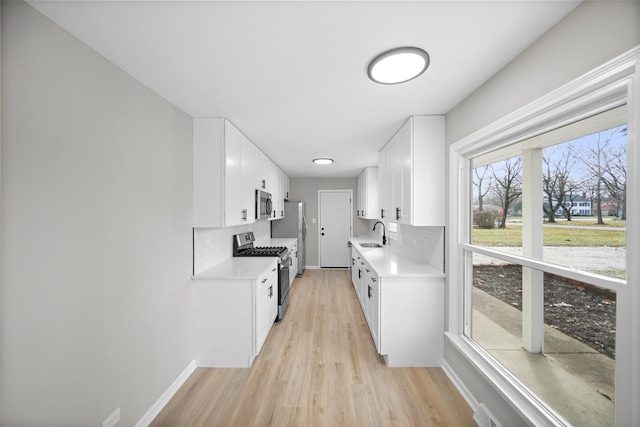 kitchen featuring white cabinets, backsplash, and stainless steel appliances