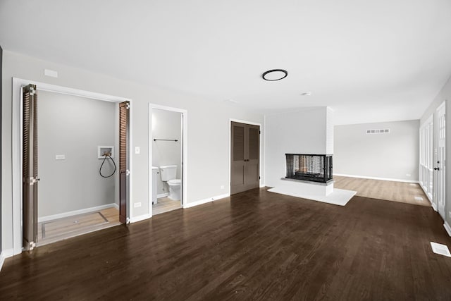 unfurnished living room featuring hardwood / wood-style flooring and a brick fireplace