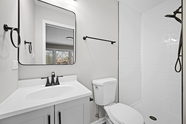 bathroom featuring vanity, toilet, and tiled shower