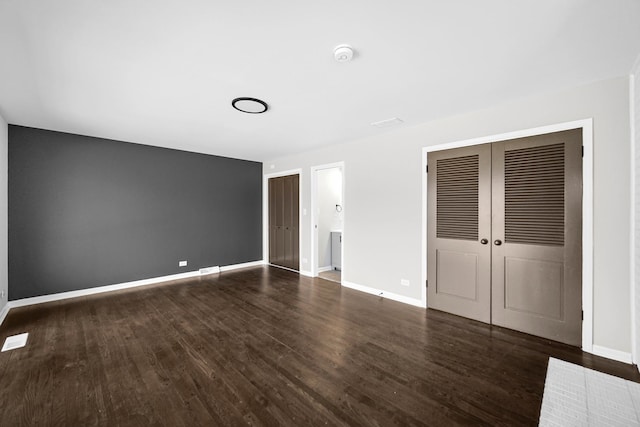 unfurnished bedroom featuring a closet and dark hardwood / wood-style floors