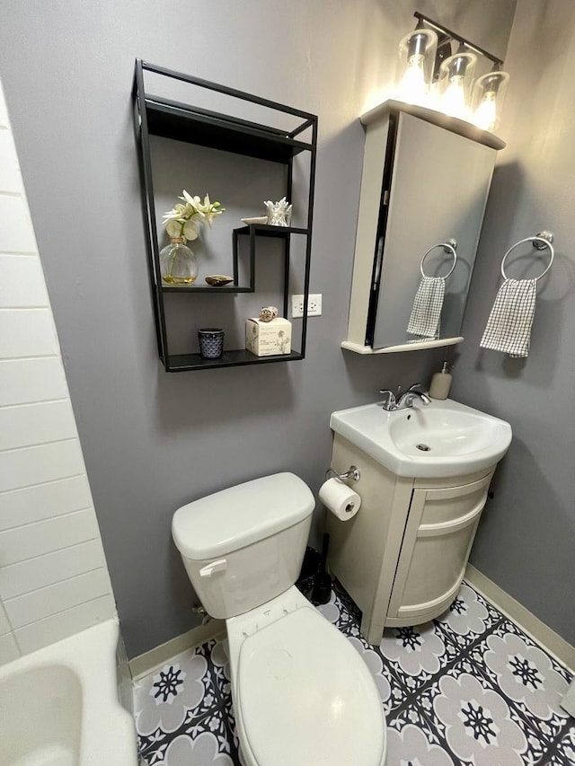 bathroom featuring tile patterned flooring, vanity, toilet, and a tub