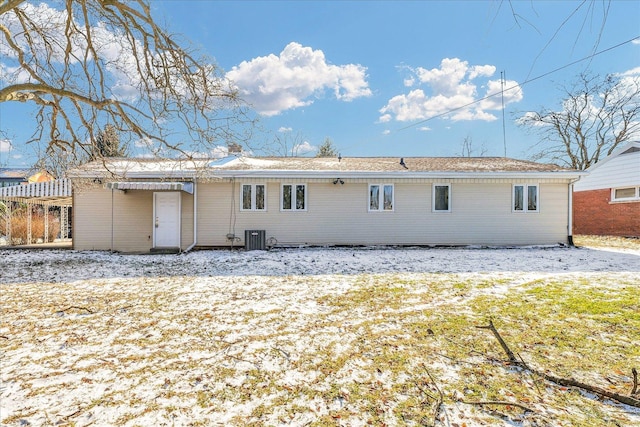 snow covered rear of property featuring central air condition unit