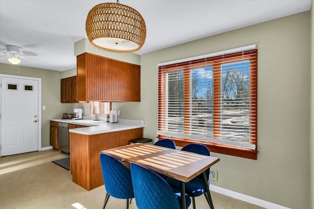 kitchen with dishwasher, sink, hanging light fixtures, kitchen peninsula, and ceiling fan