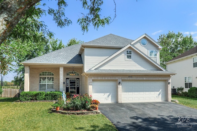 traditional home featuring brick siding, roof with shingles, fence, driveway, and a front lawn