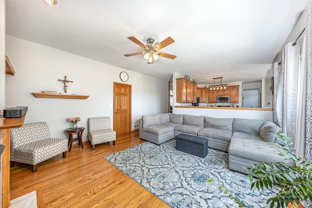 living area with light wood-style flooring and a ceiling fan