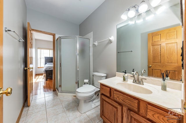 ensuite bathroom with vanity, a shower stall, toilet, and tile patterned floors