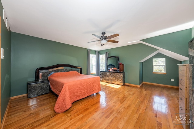 bedroom featuring a ceiling fan, baseboards, multiple windows, and hardwood / wood-style floors